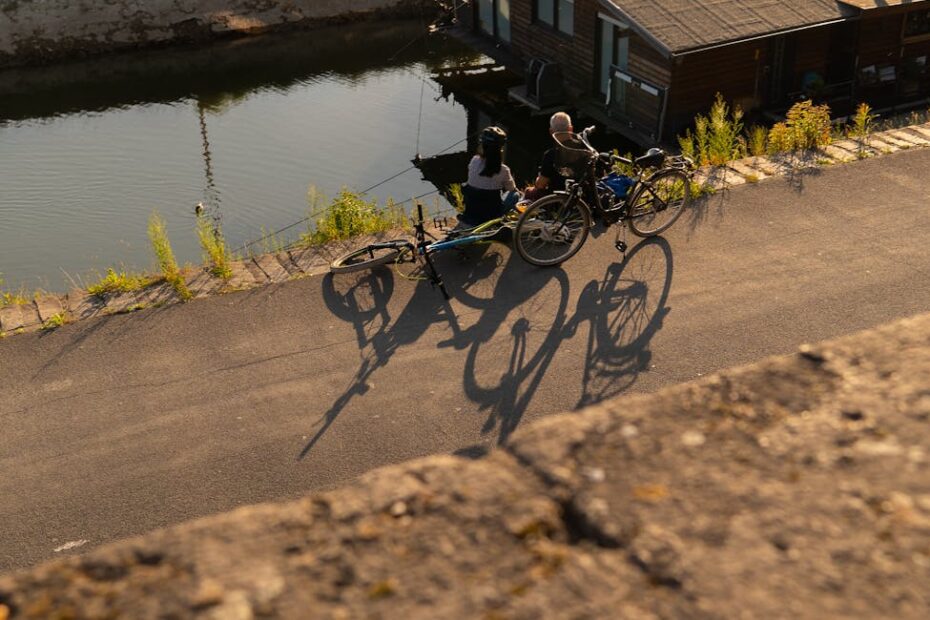 Cycliste longeant le canal de Nantes à Brest sur chemin de halage verdoyant