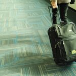 Valise cabine rouge posée sur un tapis roulant d'aéroport, prête à embarquer
