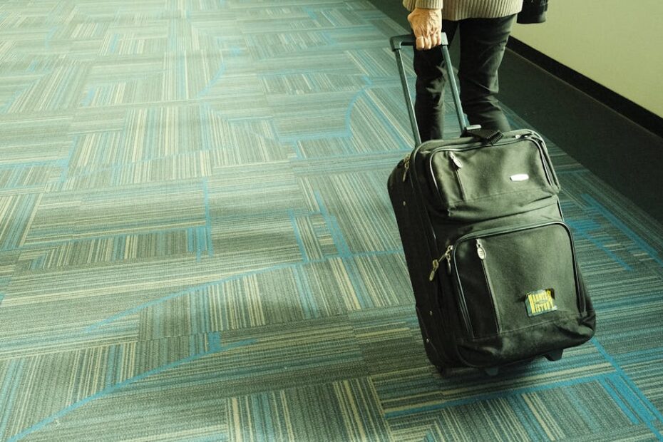 Valise cabine rouge posée sur un tapis roulant d'aéroport, prête à embarquer