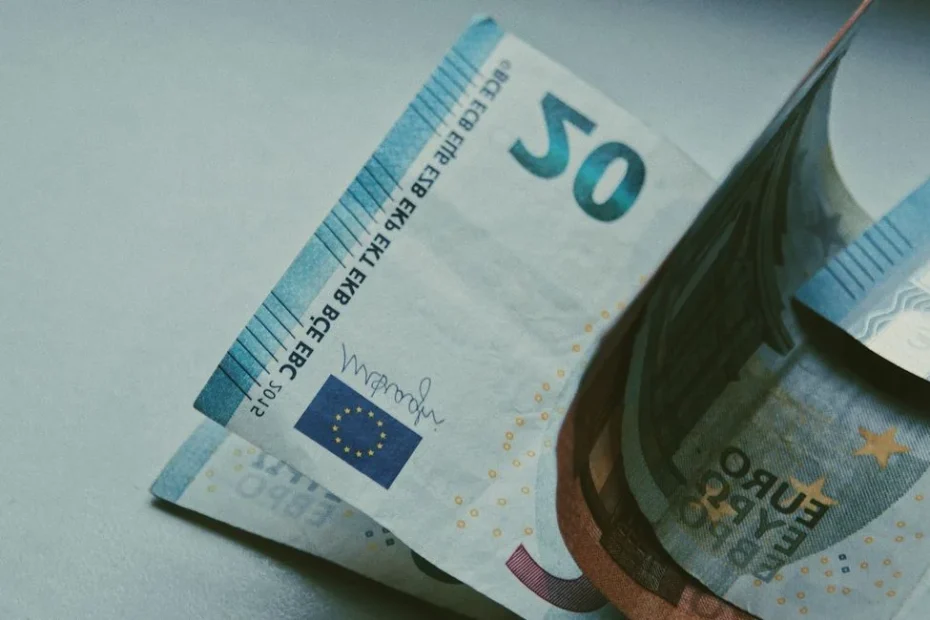 Billets en euros et dollars américains posés sur une carte du monde