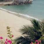 Carte postale manuscrite posée sur une serviette de plage au soleil