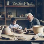 Enfants en famille qui peignent de la céramique lors d'un atelier créatif en vacances