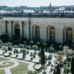 Façade dorée du château de Versailles vue depuis la cour d'honneur en journée