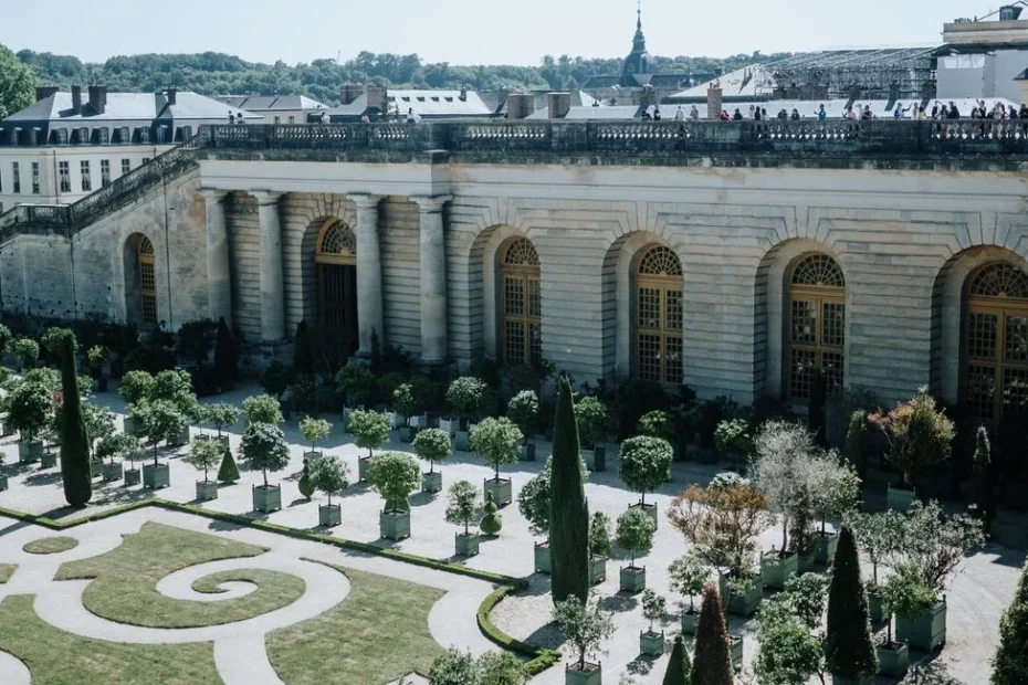 Façade dorée du château de Versailles vue depuis la cour d'honneur en journée