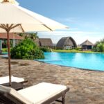 Famille en maillot de bain au bord d'une piscine d'hôtel all inclusive ensoleillé