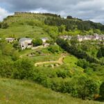Famille nombreuse installée devant un grand gîte rural en France avec enfants jouant dans le jardin