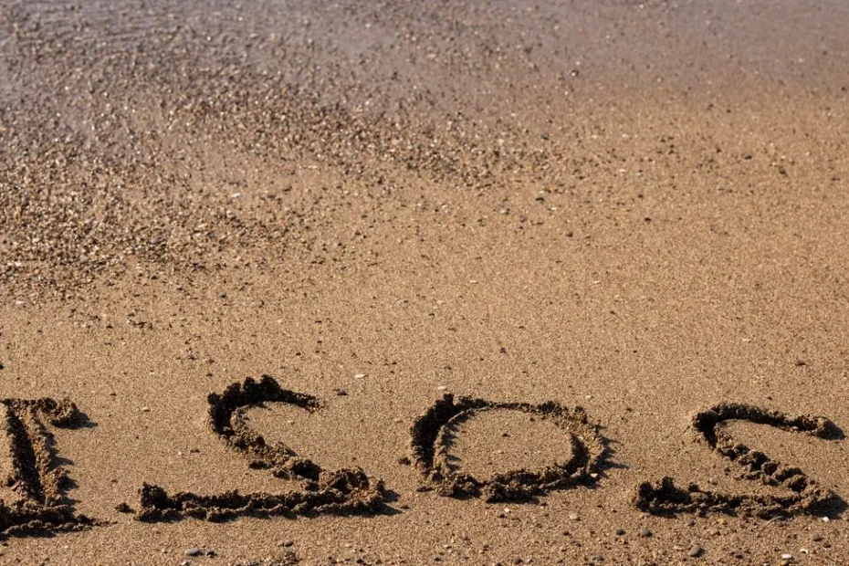 Main écrivant une carte postale sur serviette de plage ensoleillée