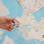 Passeport français posé sur un comptoir d'aéroport, voyageur inquiet en arrière-plan