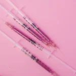 Seringue préremplie de vaccin posée sur un carnet de vaccination ouvert