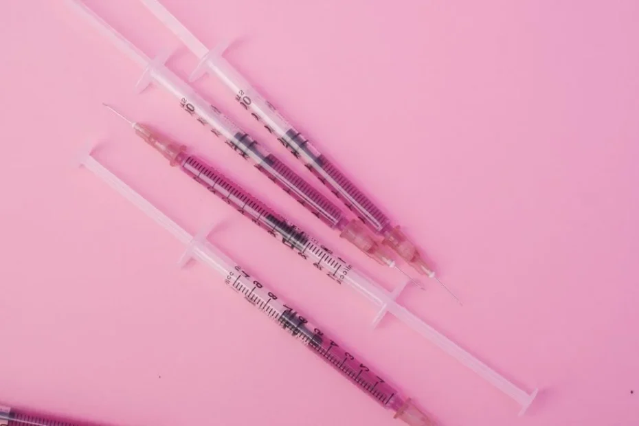 Seringue préremplie de vaccin posée sur un carnet de vaccination ouvert