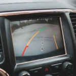 Smartphone affichant un itinéraire Google Maps sur tableau de bord voiture