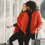 Femme tirant trolley Decathlon sur quai de gare bondé départ vacances