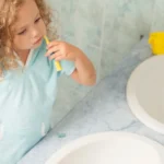 Kit brosse à dents de voyage ouvert sur lavabo d’hôtel familial