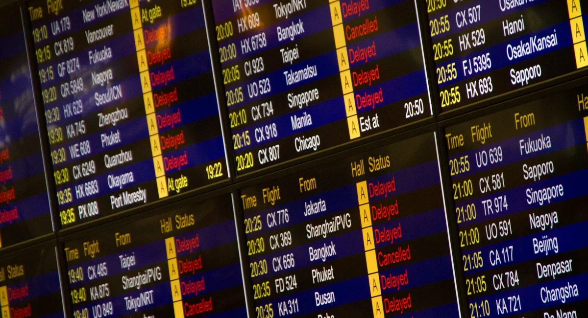 Close-up of digital flight information board showing arrivals and departures at an airport.