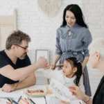 Famille autour d’une carte et d’un ordinateur, calculant leur budget vacances