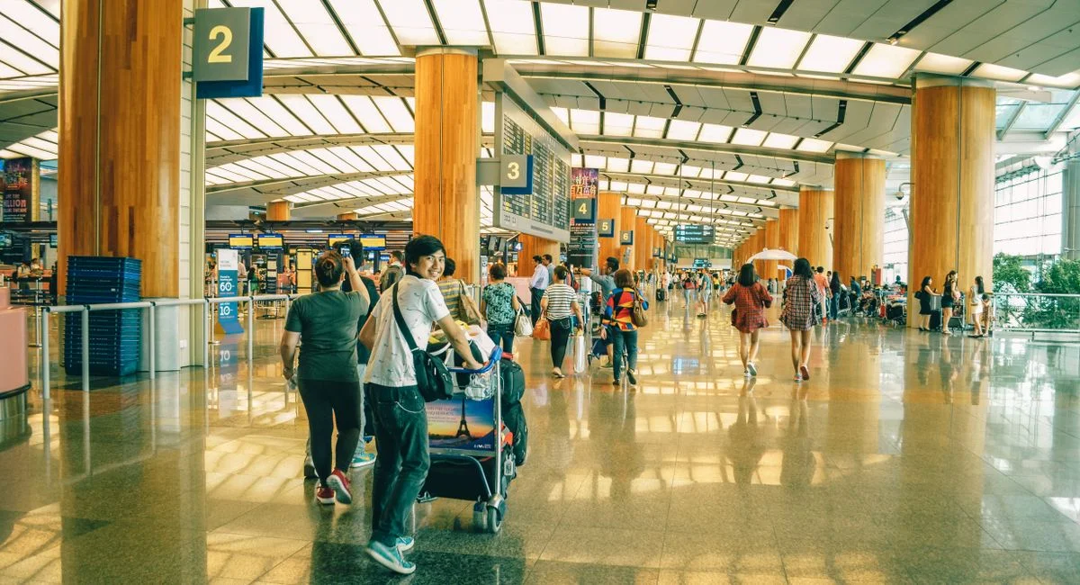 Travelers bustling through Singapore Changi Airport terminal, highlighting the dynamic and vibrant atmosphere of internationa