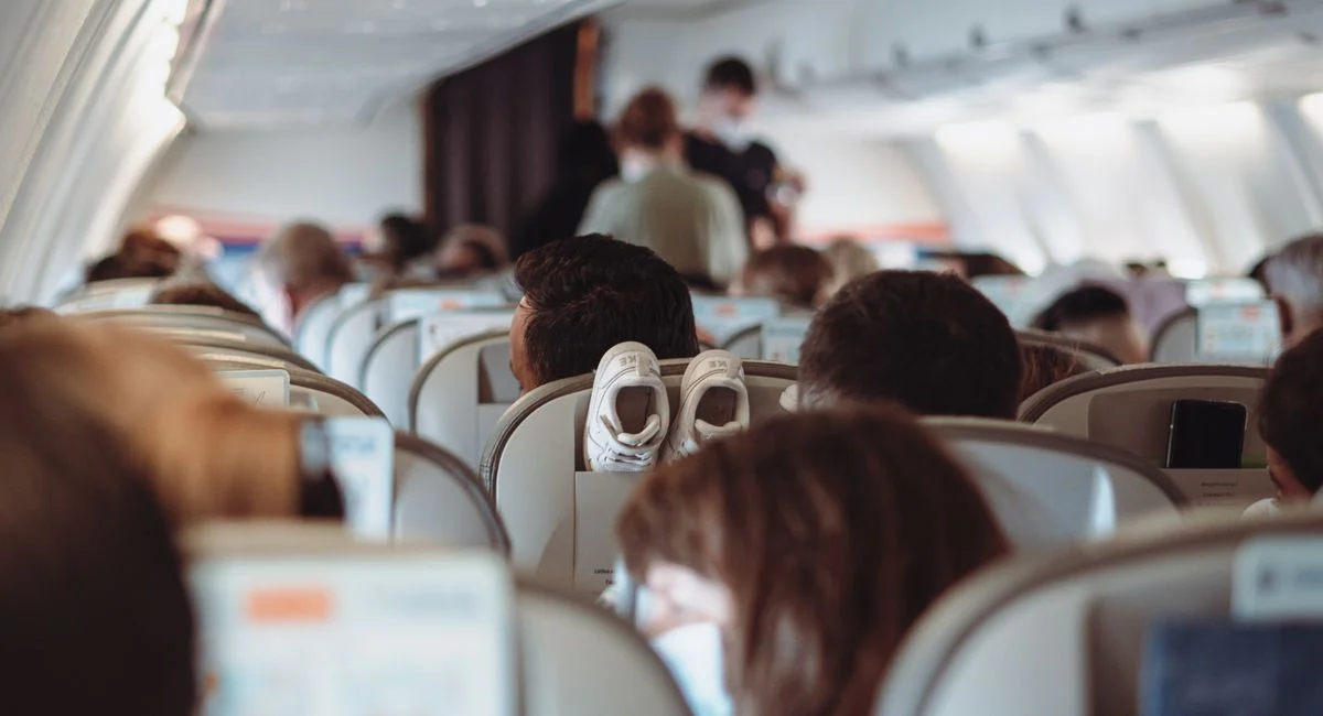 View of passengers wearing masks and seated in economy class during flight.