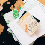 A flat lay of travel planning items on a map, featuring a compass, notebook, and guide for wanderlust enthusiasts.